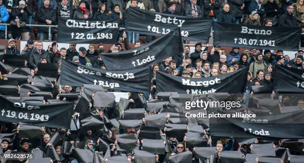 St. Pauli fans hold up banners with the names of victims of the Nazi regime for Holocaust Remembrance Day, at the German 2nd Bundesliga football...