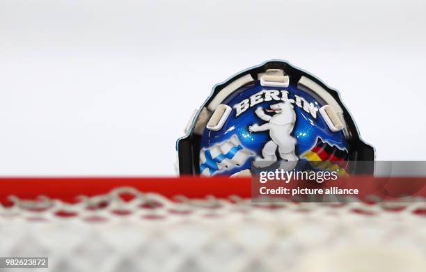 "Berlin" and a bear on the helmet of Berlin goalie Petri Vehanen, with the flags of Finland and Germany, at the DEL ice hockey match between...