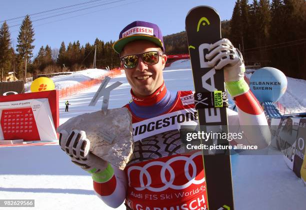 Dpatop - Winner Beat Feuz of Switzerland with his trophy after the men's downhill event at the Ski World Cup in Garmisch-Partenkirchen, Germany, 27...