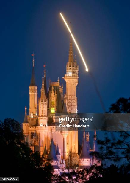 In this handout photo provided by Disney, the Space Shuttle Discovery is seen lifting off over Cinderella Castle at the Magic Kingdom on April 5,...