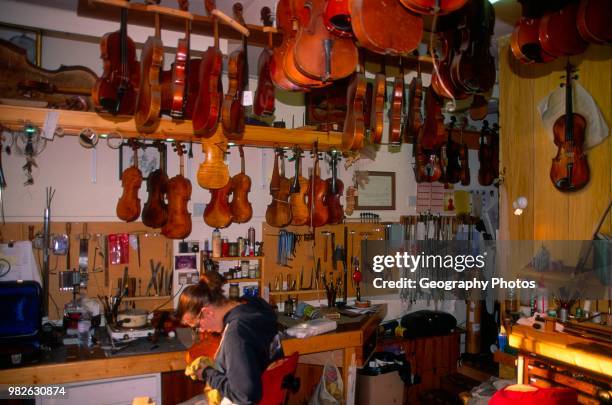 Craftswoman at work Violin shop interior Woodbridge Suffolk England.