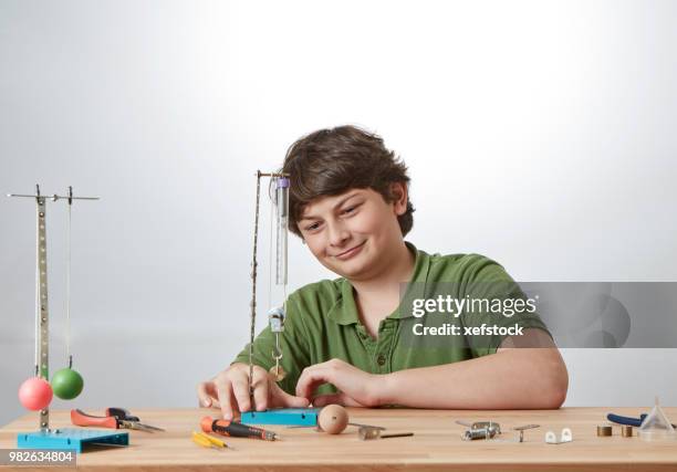 kid is doing experiments about physics. - pendulum like stock pictures, royalty-free photos & images