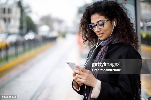 woman waiting for train at the station - streaming music stock pictures, royalty-free photos & images