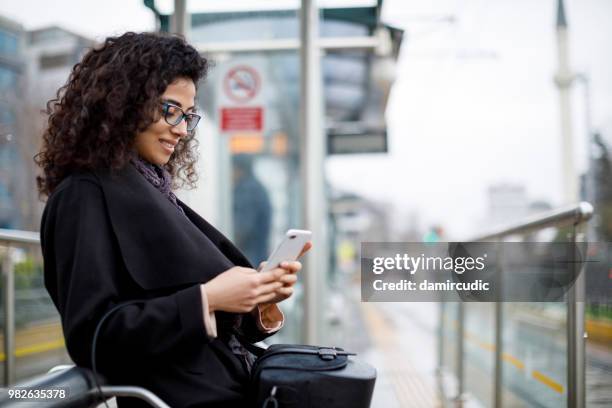 woman waiting for train at the station - damircudic stock pictures, royalty-free photos & images