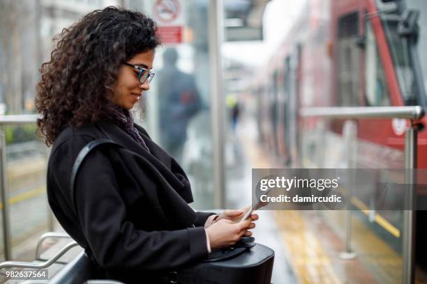 woman waiting for train at the station - damircudic stock pictures, royalty-free photos & images