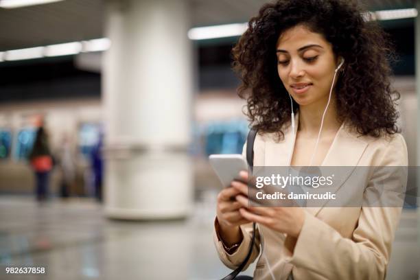 young businesswoman waiting at subway station - damircudic stock pictures, royalty-free photos & images