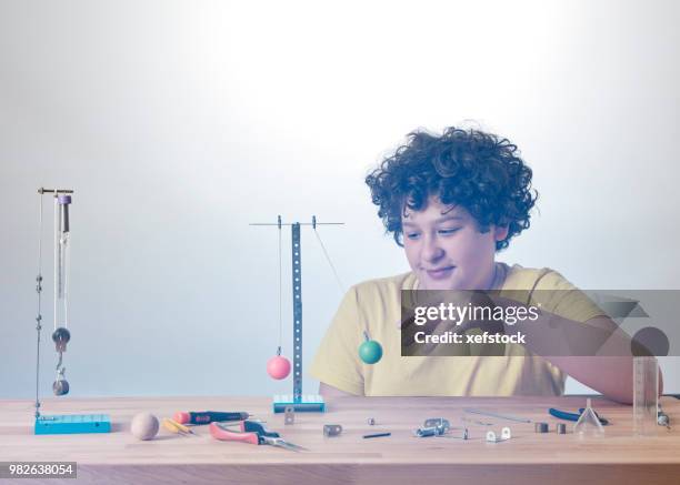 kid is doing experiments about physics. - pendulum like stock pictures, royalty-free photos & images