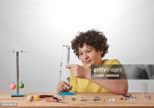 kid is doing experiments about physics. - pendulum like stock pictures, royalty-free photos & images