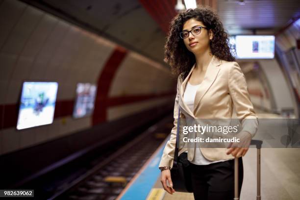 young woman waiting at subway station - damircudic stock pictures, royalty-free photos & images