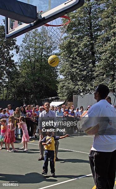 President Barack Obama cheers on Joshua Gresham of Bowie, Maryland, as he shoots a basket during a basketball skills event at the annual White House...