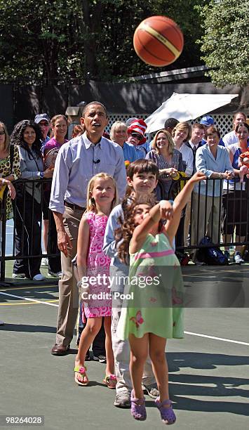 President Barack Obama cheers on kids shooting baskets during a basketball skills event at the annual White House Easter Egg Roll at the South Lawn...