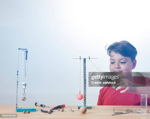 kid is doing experiments about physics. - pendulum like stock pictures, royalty-free photos & images