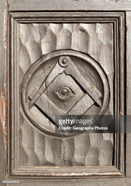 Historic carved masonic symbols on wooden panel on door of house in Marlborough, Wiltshire, England, UK.