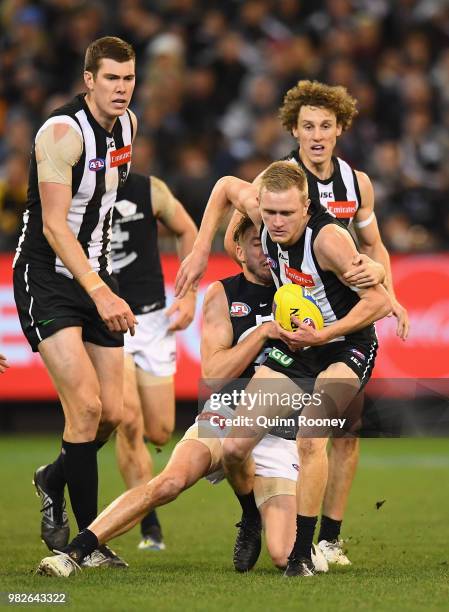 Jaidyn Stephenson of the Magpies is tackled by Dale Thomas of the Blues during the round 14 AFL match between the Collingwood Magpies and the Carlton...