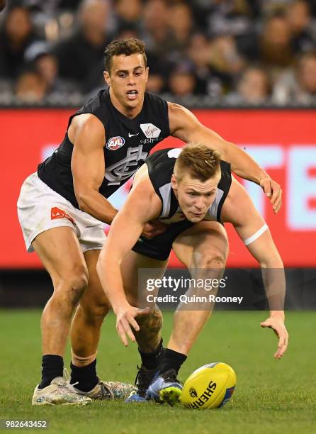 Jordan DeGoey of the Magpies is tackled by Ed Curnow of the Blues during the round 14 AFL match between the Collingwood Magpies and the Carlton Blues...