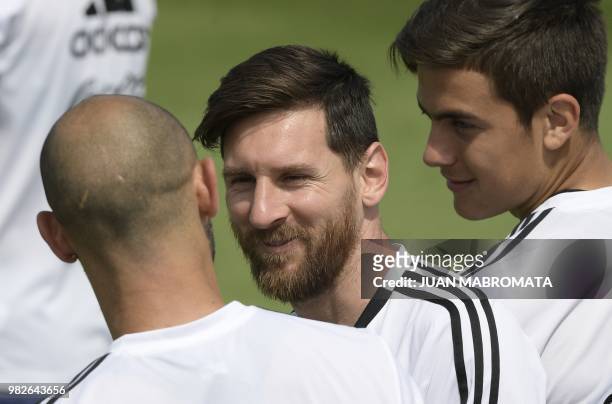 Argentina's forward Lionel Messi speaks to teammate Javier Mascherano during a training session at the team's base camp in Bronnitsy, near Moscow,...