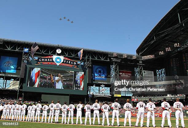 The Arizona Diamondbacks stand attended as Joe Nichols sings the National Anthem before the Opening Day major league baseball game against the San...