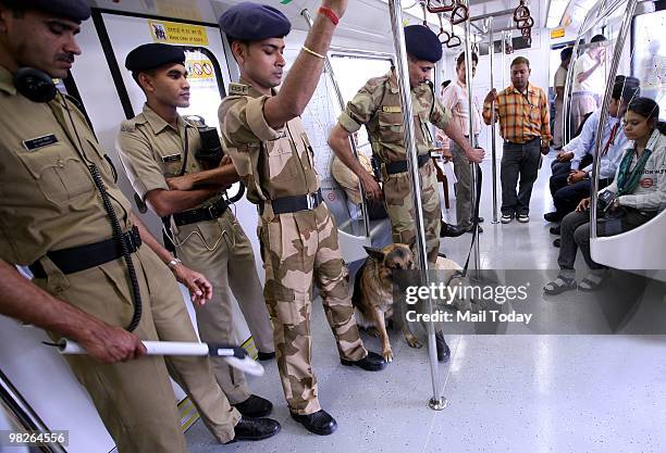 Security men stand with sniffer dogs inside the first train running on Inderlok-Mundka Line of Phase-ll in New Delhi on Friday, April 2, 2010. The...