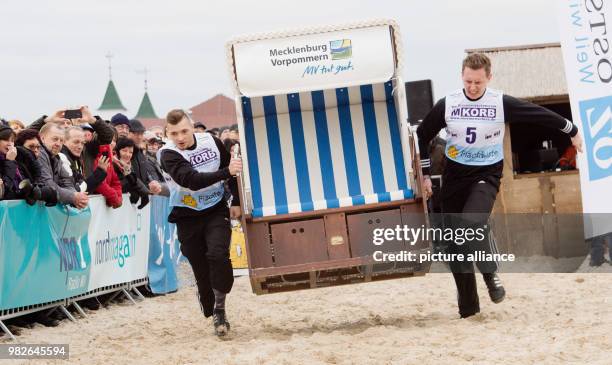 Participants sprint down the beach on the island Usedom carrying wicker beach chairs at the Beach Chair Sprinting World Cup in Ahlbeck, Germany, 27...