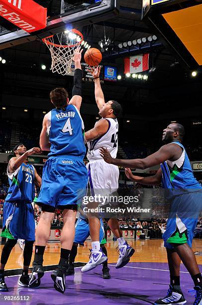 Sean May of the Sacramento Kings shoots against Oleksiy Pecherov and Corey Brewer of the Minnesota Timberwolves during the game on March 14, 2010 at...