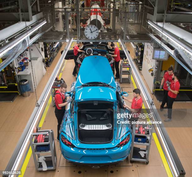 Staff members assemble a Porsche 718 Cayman at the assembly plant of car maker Porsche AG in Stuttgart, Germany, 26 January 2018. Photo: Marijan...