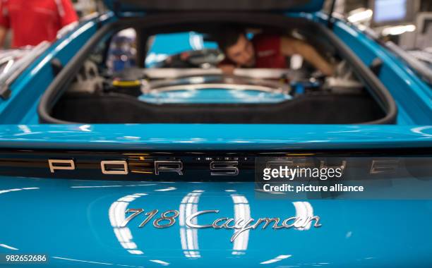 Employees work on a car of the model 718 Cayman at a manufacturing facility of German automobile company Porsche in Stuttgart, Germany, 26 January...