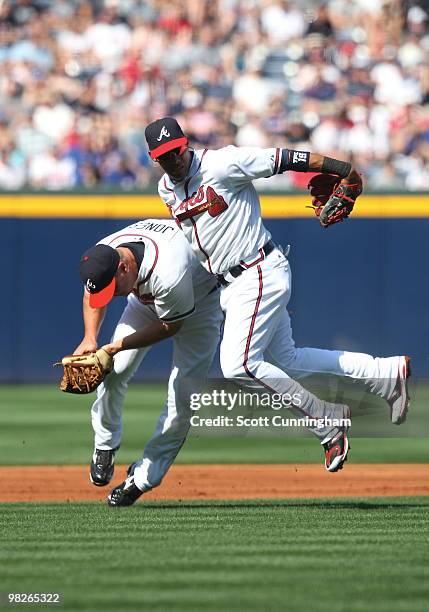 Chipper Jones of the Atlanta Braves collides with Yunel Escobar while fielding a grounder against the Chicago Cubs during Opening Day at Turner Field...