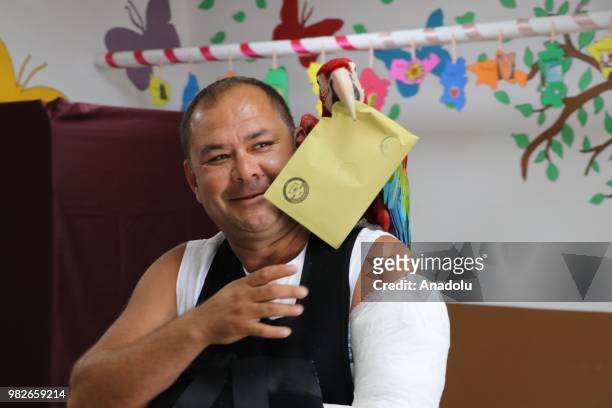 Voter with his parrot casts his ballot at a polling station during the parliamentary and presidential elections, in Pamukkale district of Denizli,...