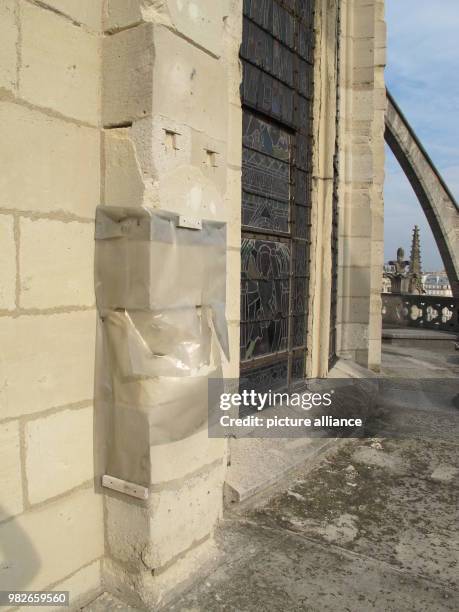 Damaged parts of the Notre-Dame Cathedral are covered with a plastic sheet for rain protection in Paris, France, 27 September 2017. The air pollution...