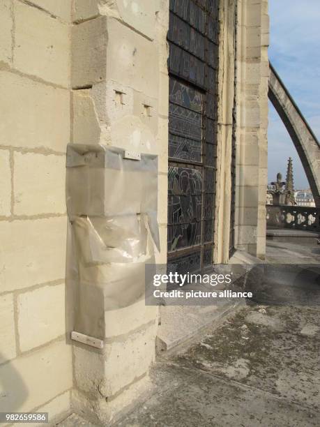 Damaged parts of the Notre-Dame Cathedral are covered with a plastic sheet for rain protection in Paris, France, 27 September 2017. The air pollution...