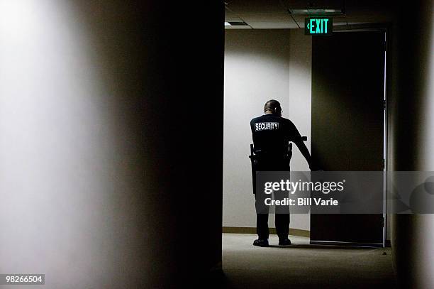 security guard checking hallways - bewaker stockfoto's en -beelden