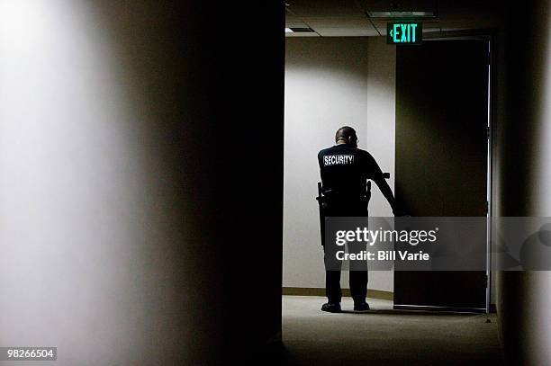 security guard checking hallways - security man stock pictures, royalty-free photos & images