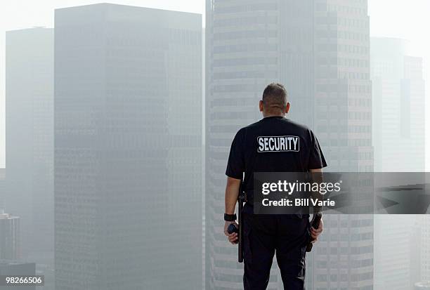 security officer on roof of building - bewaker stockfoto's en -beelden