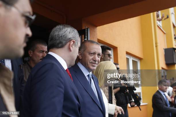 Recep Tayyip Erdogan, Turkey's president, center, exits a polling station after voting during parliamentary and presidential elections in the...