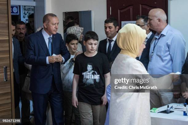 Turkey's President Recep Tayyip Erdogan and wife Emine Erdogan arrive to cast their vote in the countries parliamentary and presidential election on...