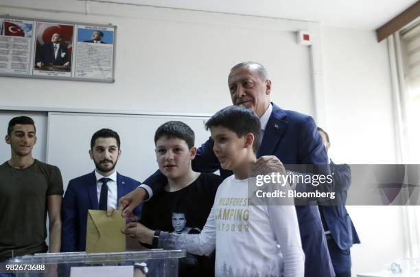 Recep Tayyip Erdogan, Turkey's president, right, cast his ballot with the help of his grandchildren at a polling station during parliamentary and...