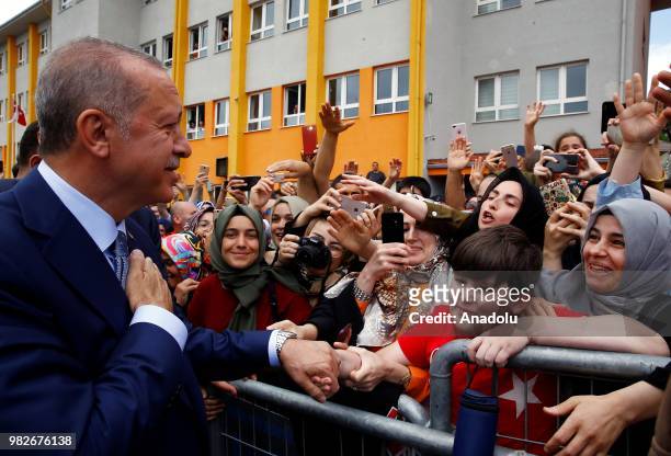 Turkish President Recep Tayyip Erdogan greets citizens after casting his vote at a polling station during the parliamentary and presidential...