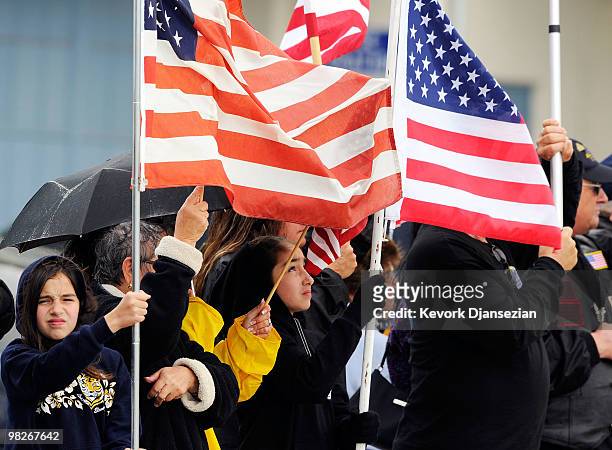 Members of the public line the tarmac with American flags to honor LAPD SWAT officer and US Marine reservist Sgt. Maj. Robert J. Cottle, killed March...