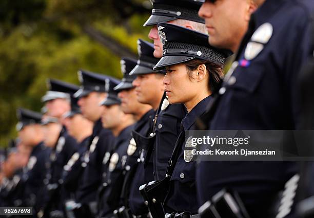 Members of Los Angeles Police Department Metro Division line the route before a hearse carrying the remains of LAPD SWAT officer and US Marine...