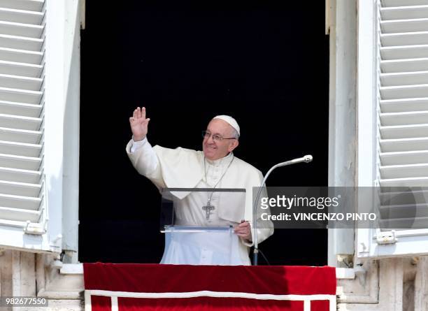 Pope Francis waves after delivering his message to pilgrims gathered at Saint Peter's square, during his Angelus Sunday prayer at the Vatican on June...