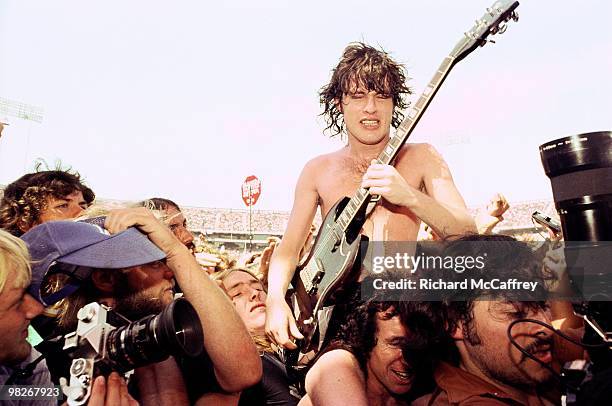 Angus Young and Bon Scott of AC/DC get swept away by fans and media at The Oakland Coliseum 1978 in Oakland, California.