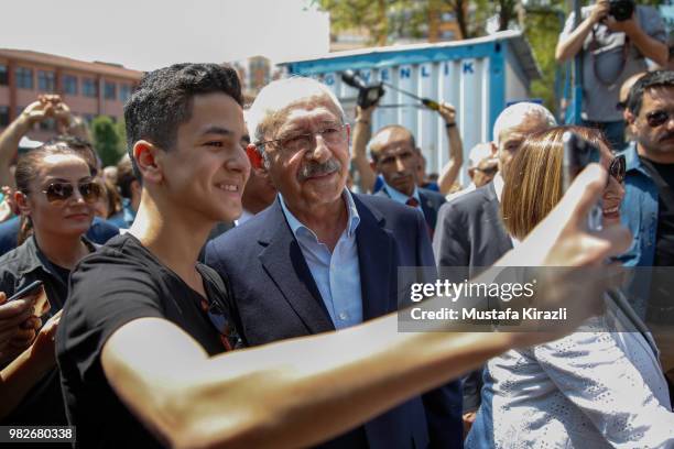 Turkey's main opposition Republican People's Party Kemal Kilicdaroglu takes a selfie with a supporter after casting his vote at a polling station...