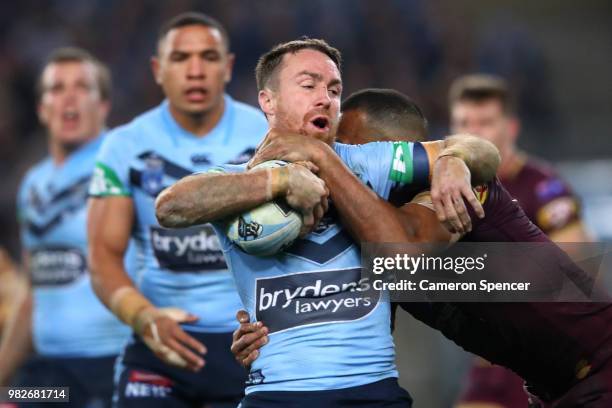 James Maloney of the Blues is tackled by Will Chambers of Queensland during game two of the State of Origin series between the New South Wales Blues...