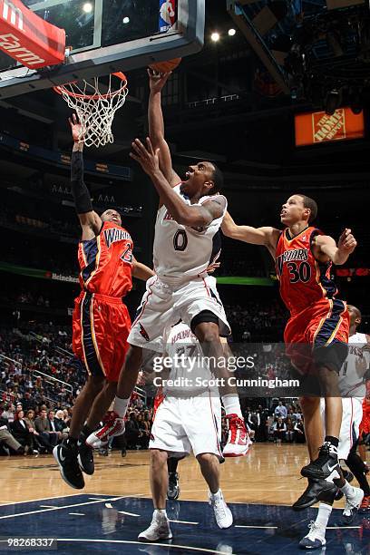 Jeff Teague of the Atlanta Hawks shoots a layup against C.J. Watson and Stephen Curry of the Golden State Warriors during the game at Philips Arena...