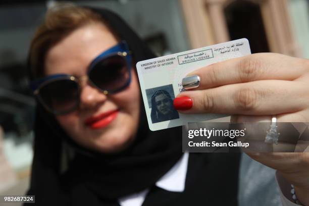 Nada Edlibi holds up her Saudi Arabian driver's license on the first day that she is legally allowed to drive in Saudi Arabia on June 24, 2018 in...