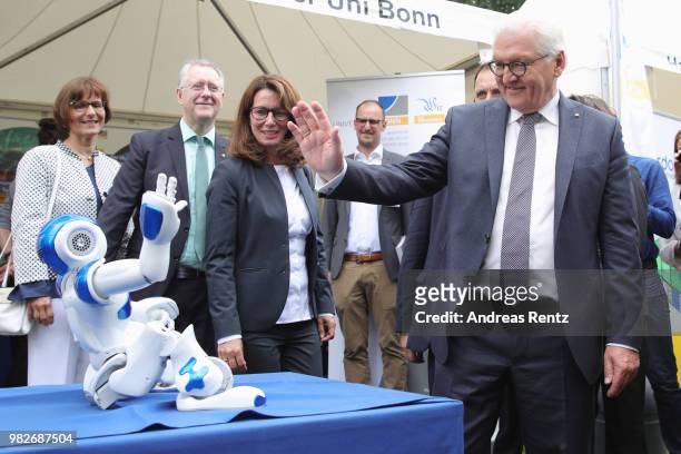 German President Frank-Walter Steinmeier waves to a robotor upon his visit at Research University of Bonn booth during the open-house day at Villa...