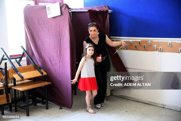 Woman and her daughter come out of a voting booth at a polling station during snap twin Turkish presidential and parliamentary elections in Ankara,...