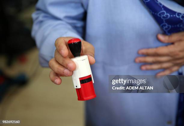 Picture shows a woman holding a stamp at a polling station during snap twin Turkish presidential and parliamentary elections in Ankara, on June 24,...