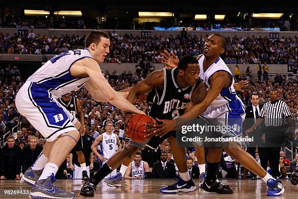 Shawn Vanzant of the Butler Bulldogs looks to pass the ball in the first half as he is defended by Miles Plumlee and Nolan Smith of the Duke Blue...