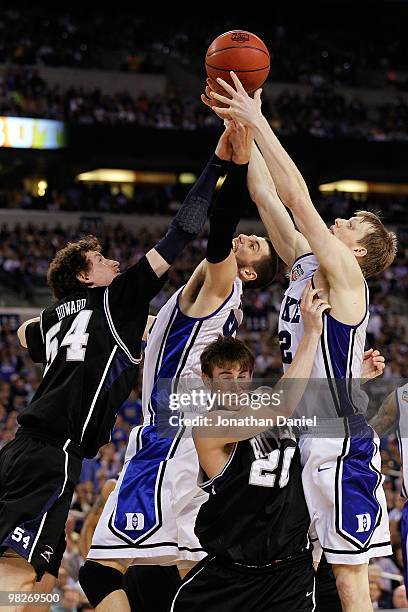 Matt Howard and Gordon Hayward of the Butler Bulldogs fight for a rebound in the second half against Brian Zoubek and Kyle Singler of the Duke Blue...
